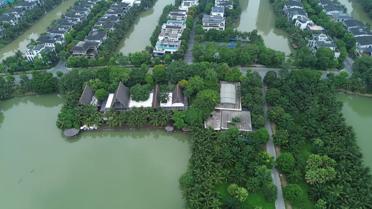 Clubhouse mái nhọn của khu biệt thự đảo Ecopark nằm sát mép hồ, bao quanh là hàng dừa