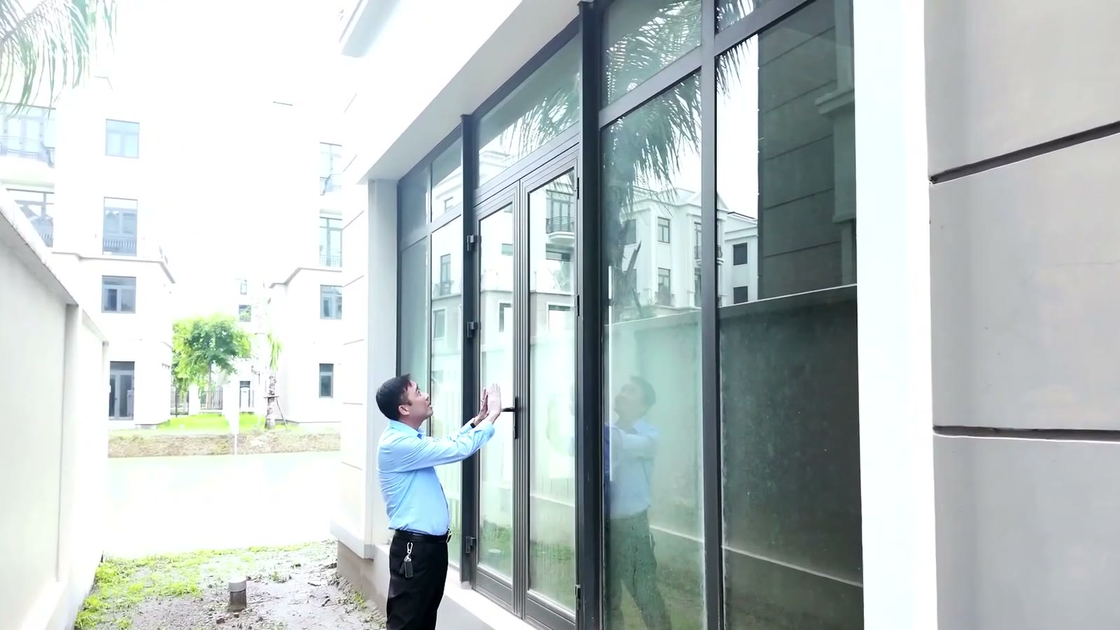 Cửa kính khung nhôm phía sau một căn song lập Đảo Ngọc mở ra khoảng đất giáp mặt nước