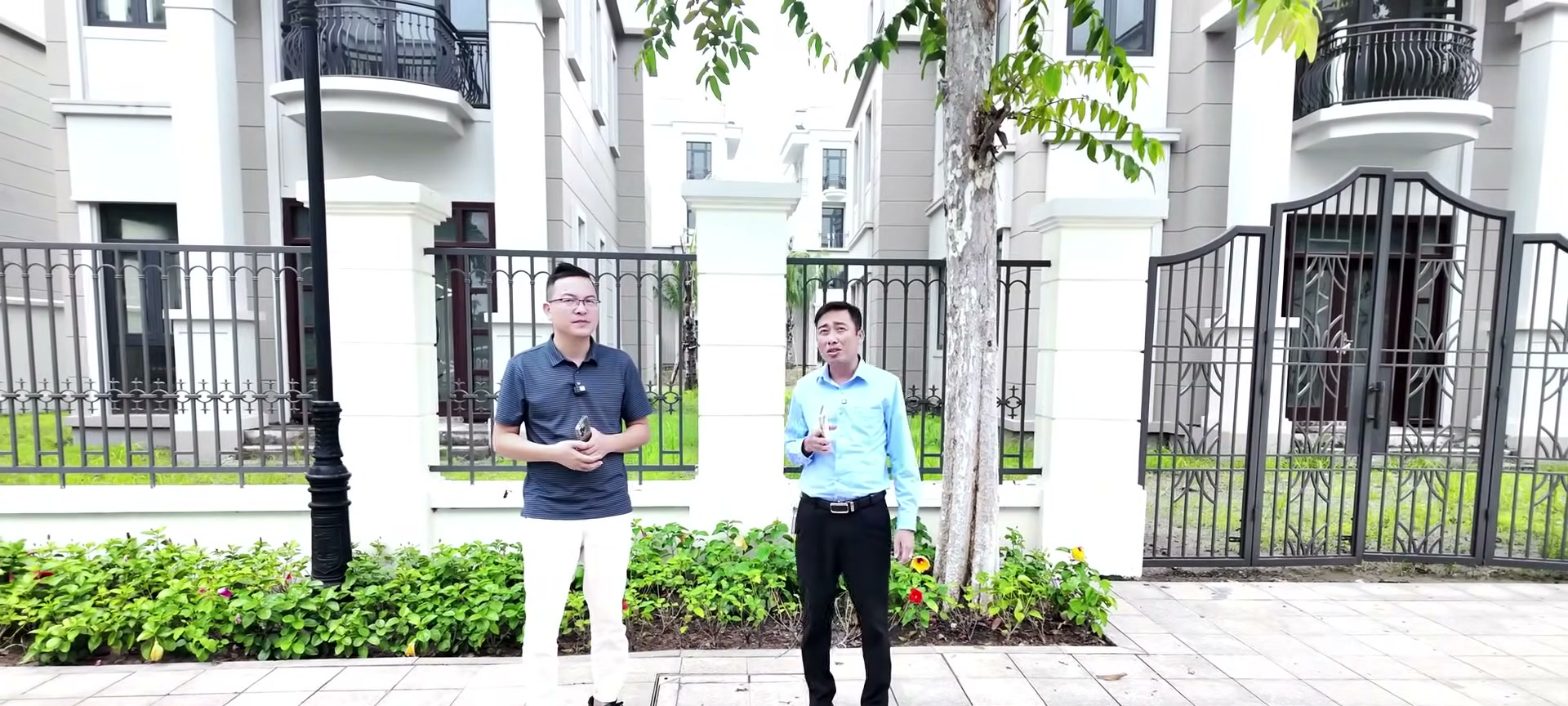 Lê Ngọc Lương và anh Nguyễn Văn Bắc đứng trao đổi trước một căn biệt thự đơn lập trong phân khu Đảo Ngọc Ocean Park 3