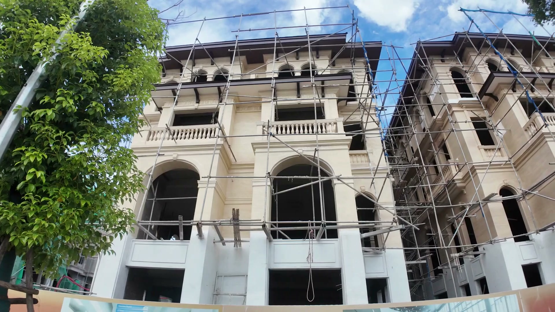 Cận cảnh phần mái vòm và các ô cửa cuốn của căn song lập Alluvia City khi còn giàn giáo, thấy rõ đường viền và chi tiết phù điêu