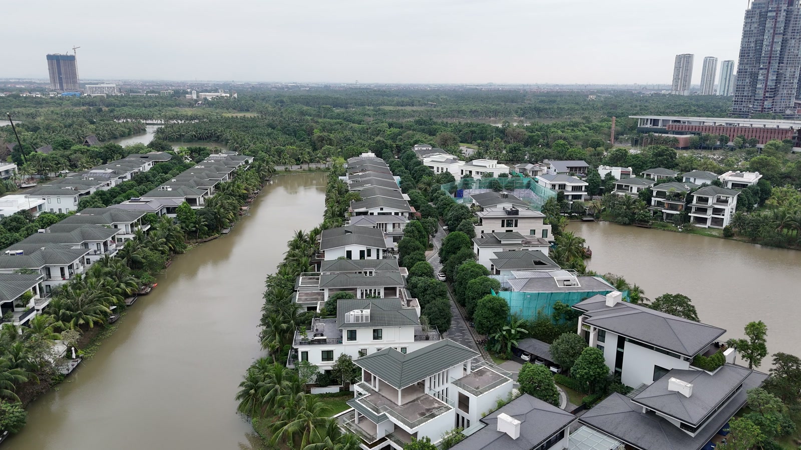 Một nhánh đảo Ecopark chạy dài, dòng sông bao quanh hai bên, phía xa là các tòa căn hộ cao tầng