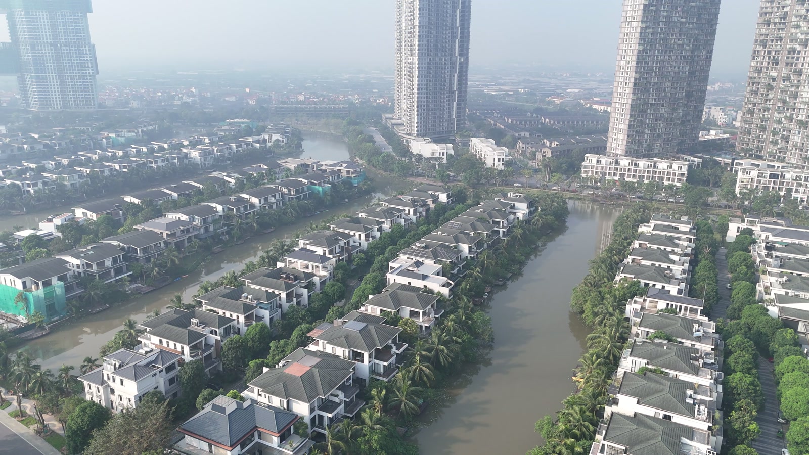 Dãy biệt thự trên nhánh đảo Ecopark nằm gần những tòa căn hộ cao tầng, hai bên là mặt nước