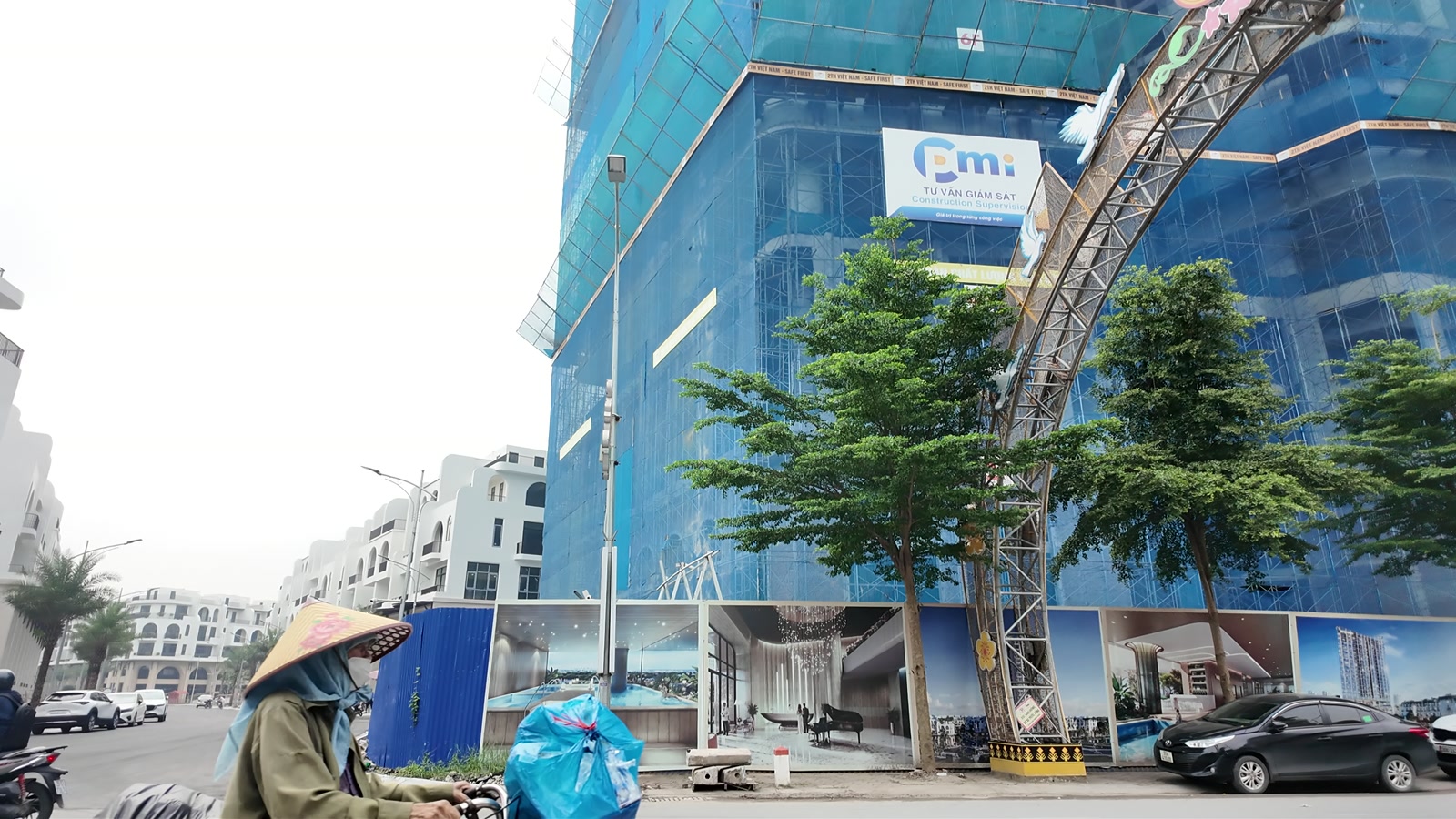 Tòa căn hộ cao tầng của Vaquarius Văn Giang đang xây dựng, phủ lưới xanh, bên cạnh là các dãy nhà thấp tầng đã hoàn thiện