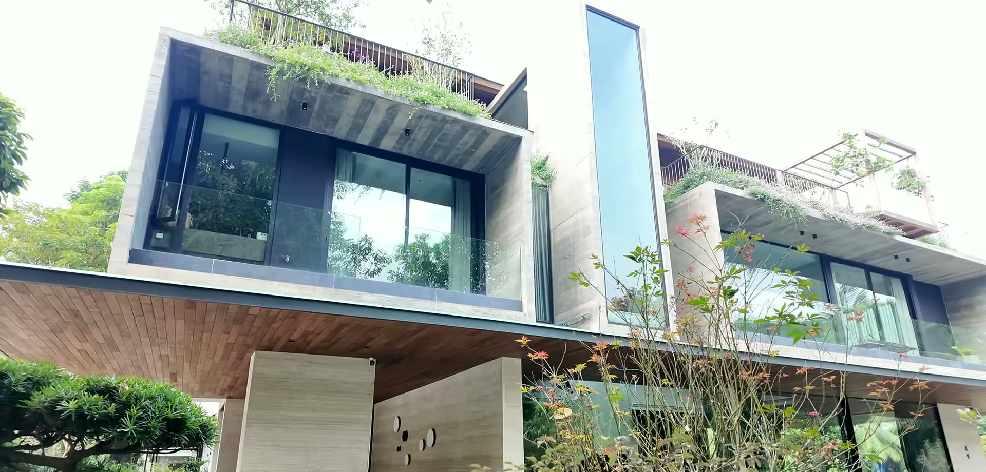 Mặt đứng căn biệt thự đầu hồi Ecopark với khối bê tông mộc, ban công kính và vườn cây trên mái tầng hai
